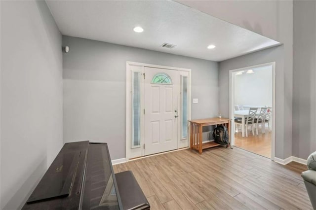 foyer with wood finished floors, baseboards, and recessed lighting