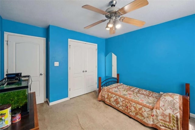 bedroom featuring carpet, a closet, baseboards, and ceiling fan