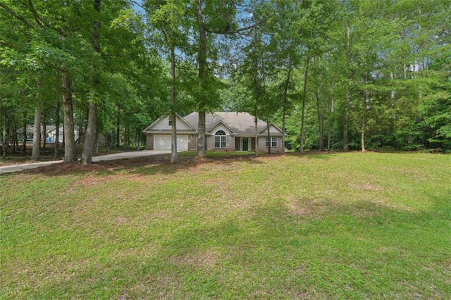 view of front of property featuring an attached garage, a front lawn, and driveway