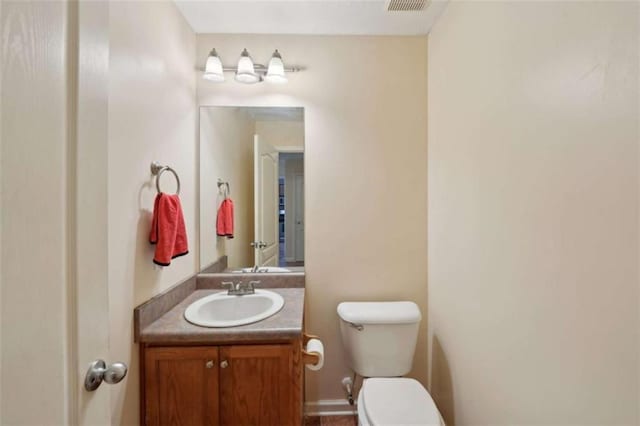 half bathroom with toilet and vanity