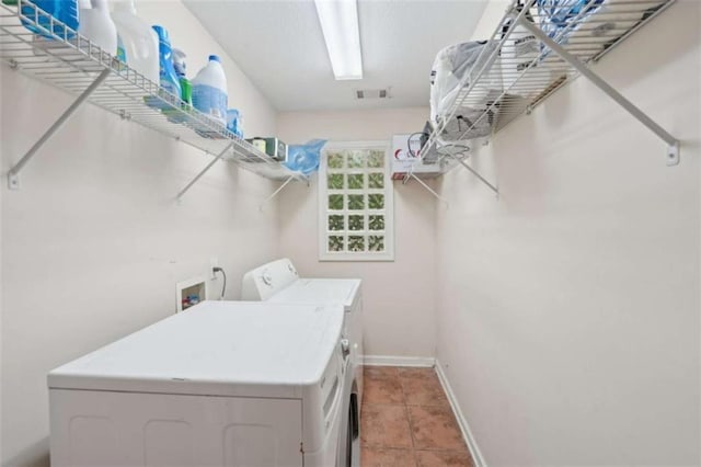 laundry room with washer and dryer, baseboards, and light tile patterned floors