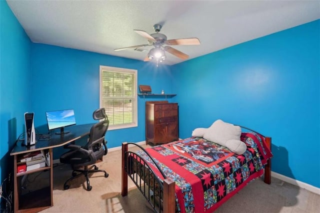 carpeted bedroom with baseboards, an office area, and ceiling fan