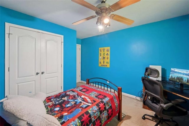 carpeted bedroom featuring a closet, baseboards, and a ceiling fan