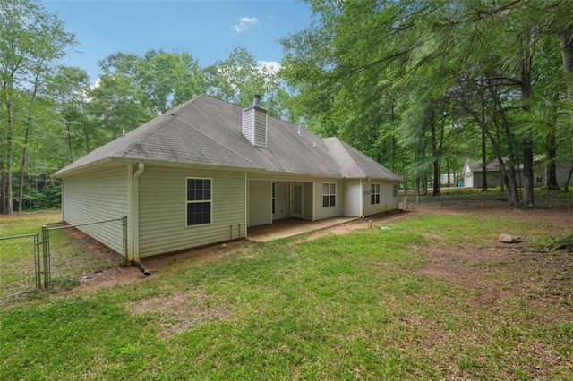 back of house with a patio area, a chimney, and a gate