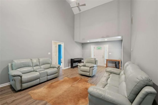 living room with high vaulted ceiling, wood finished floors, baseboards, and a ceiling fan