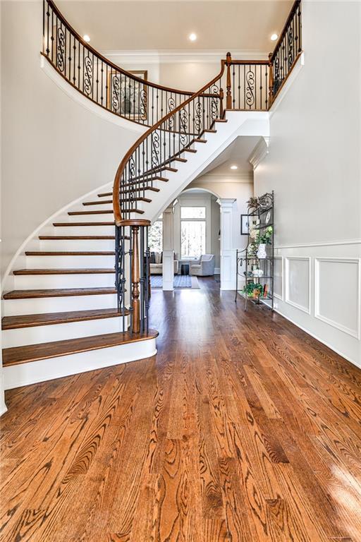 620 Elizabeth Oak Ct, Alpharetta, GA 30004 - stairway with decorative columns, arched walkways, a high ceiling, ornamental molding, and wood finished floors