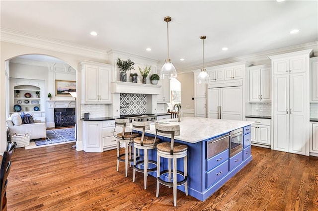 620 Elizabeth Oak Ct, Alpharetta, GA 30004 - kitchen featuring blue cabinetry, white cabinets, built in appliances, arched walkways, and ornamental molding