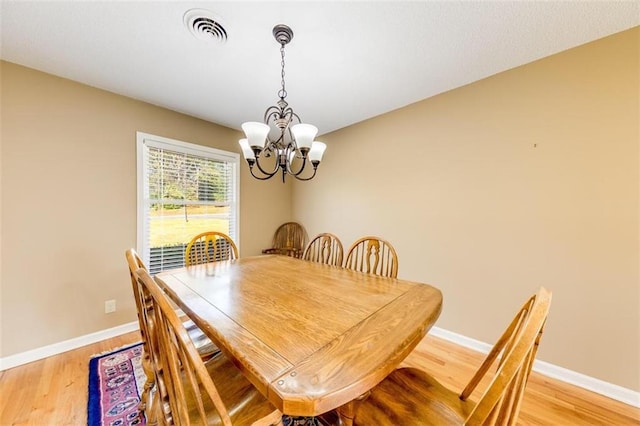 dining area featuring a notable chandelier and light wood-type flooring