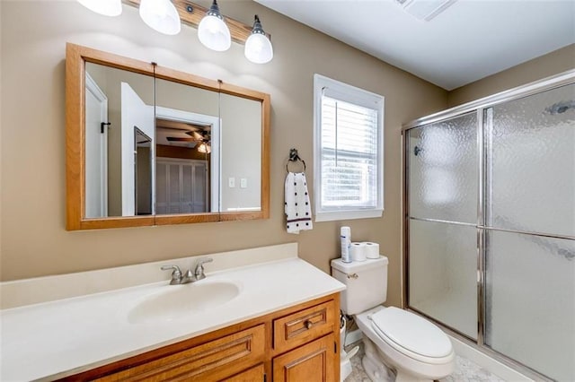 bathroom with vanity, an enclosed shower, toilet, and ceiling fan