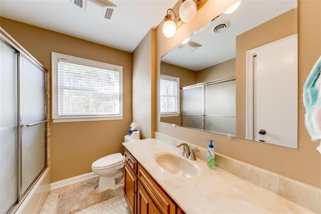 full bathroom featuring tile patterned floors, vanity, enclosed tub / shower combo, and toilet