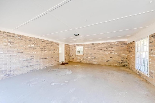 empty room with concrete floors and brick wall