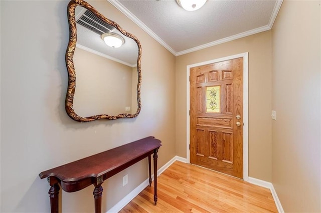 entrance foyer featuring hardwood / wood-style floors, ornamental molding, and a textured ceiling