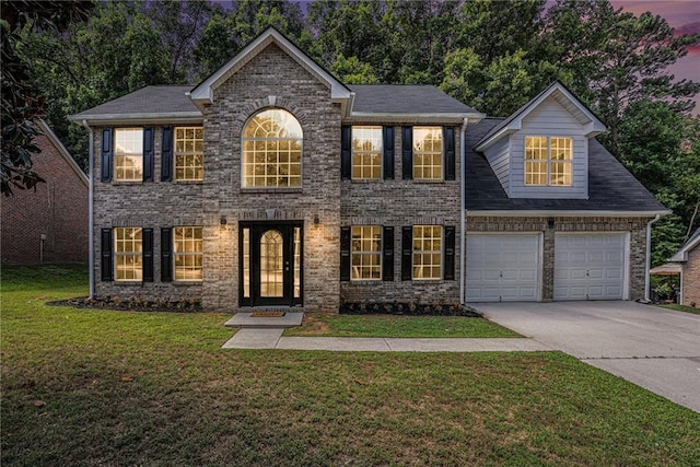 colonial-style house with a yard and a garage