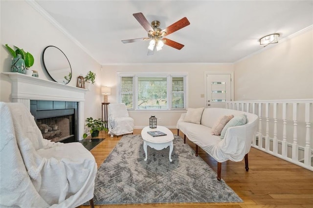 living room featuring crown molding, a tile fireplace, and light hardwood / wood-style flooring