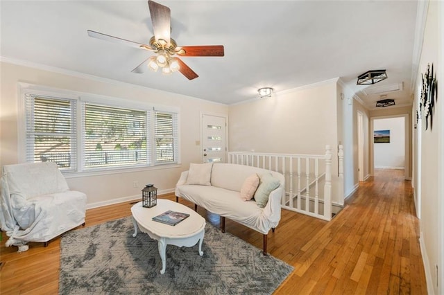 living room featuring crown molding, ceiling fan, and light wood-type flooring