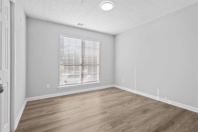 spare room with wood-type flooring and a textured ceiling