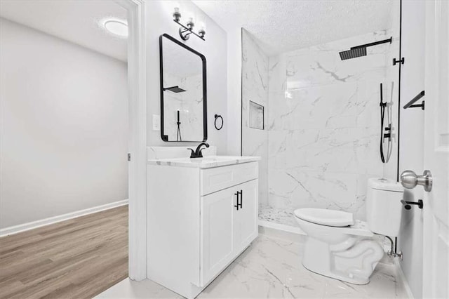 bathroom with a tile shower, wood-type flooring, a textured ceiling, toilet, and vanity