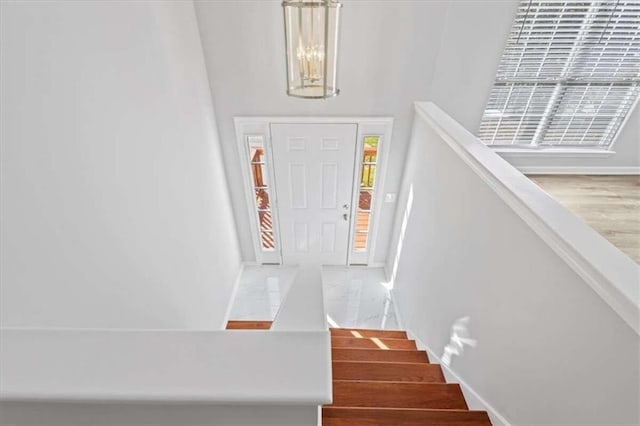 staircase with a chandelier and hardwood / wood-style floors