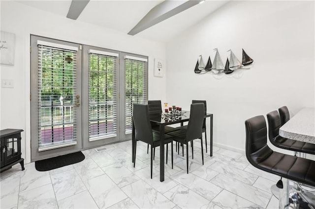 dining room with lofted ceiling, marble finish floor, and baseboards