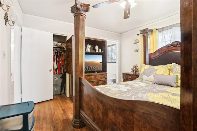 bedroom featuring ceiling fan, ornamental molding, a closet, and wood finished floors