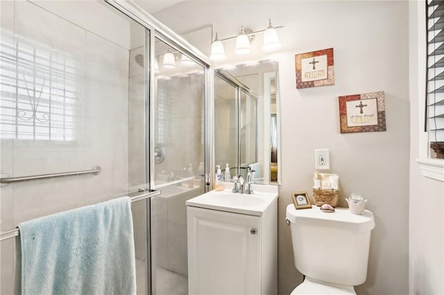 full bathroom featuring a stall shower, vanity, and toilet