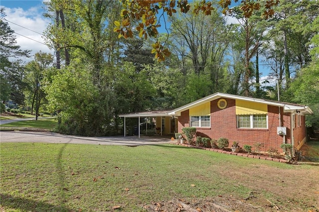 view of front facade featuring a front lawn, an attached carport, concrete driveway, and brick siding