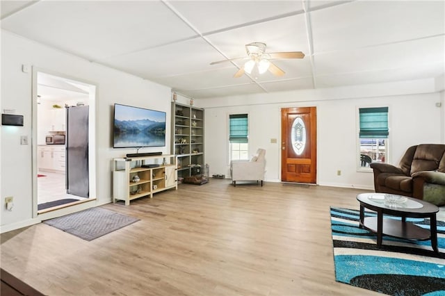 living room with ceiling fan, wood finished floors, and baseboards