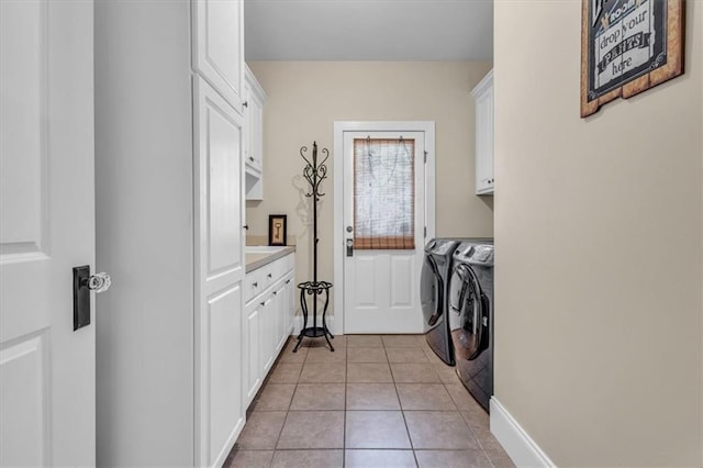 clothes washing area featuring baseboards, cabinet space, independent washer and dryer, and light tile patterned floors