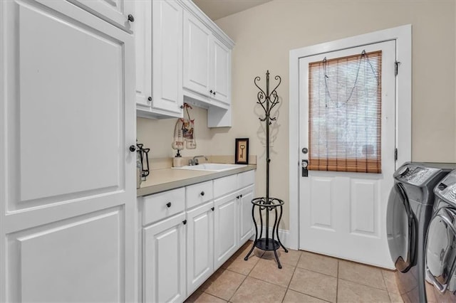 laundry room featuring light tile patterned floors, a sink, cabinet space, and washing machine and dryer