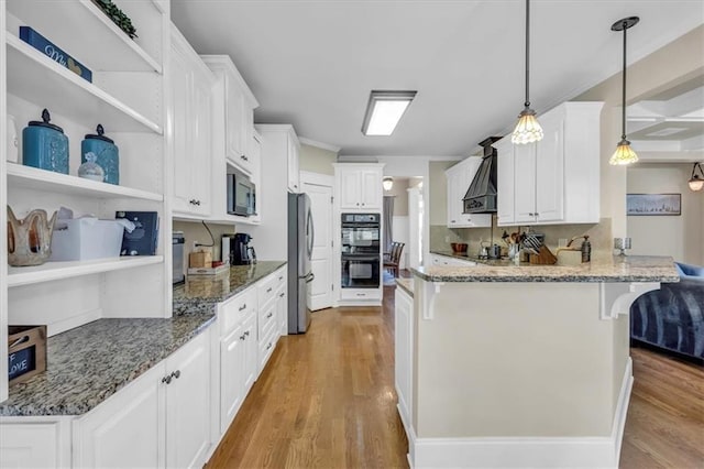 kitchen with a peninsula, dobule oven black, open shelves, built in microwave, and freestanding refrigerator
