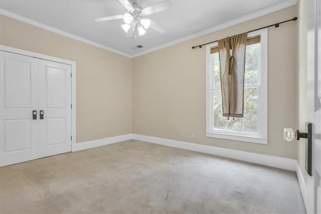 unfurnished bedroom with a closet, visible vents, baseboards, ornamental molding, and light colored carpet