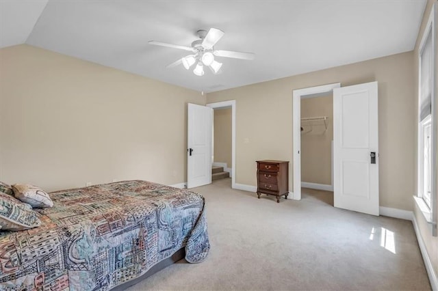 bedroom featuring light colored carpet, vaulted ceiling, baseboards, ceiling fan, and a closet