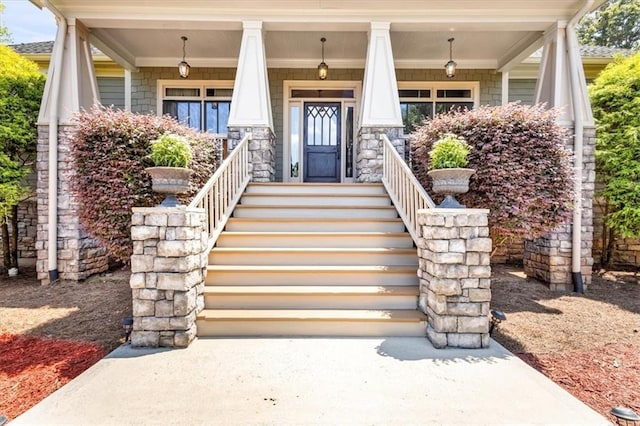 doorway to property with stone siding and covered porch