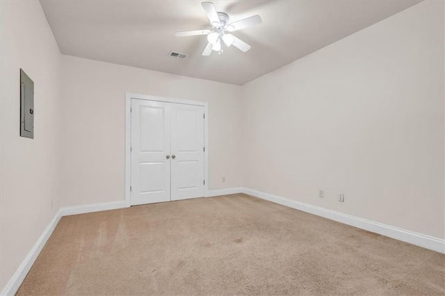 unfurnished bedroom featuring electric panel, a closet, carpet floors, baseboards, and visible vents