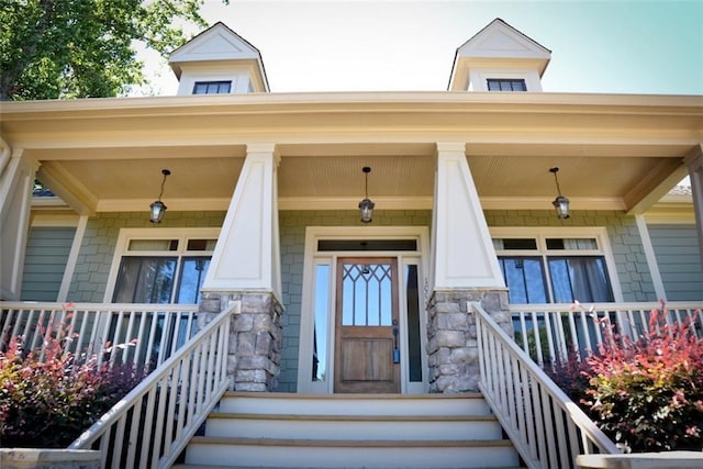 entrance to property featuring stone siding and covered porch