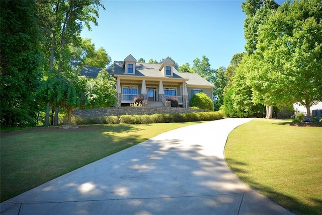 cape cod home with a porch, driveway, and a front lawn