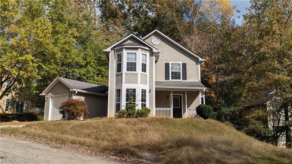 view of property featuring a garage and covered porch