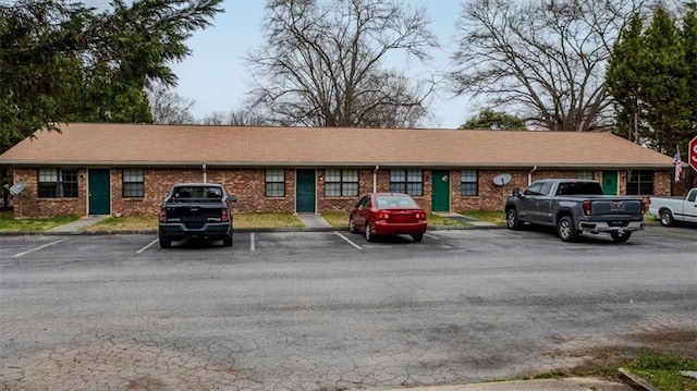 view of front of property with uncovered parking and brick siding