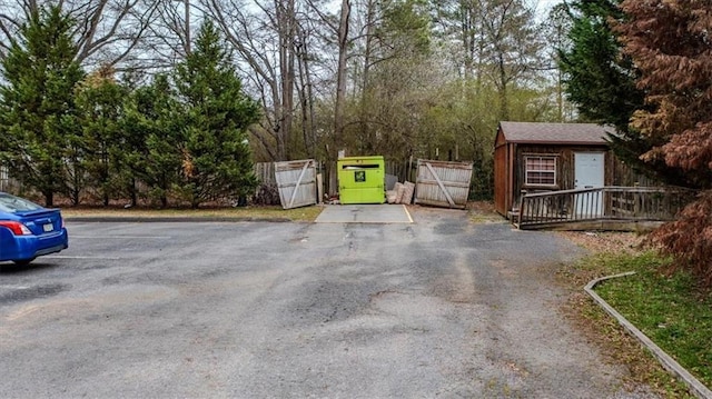 view of road featuring aphalt driveway and a gate