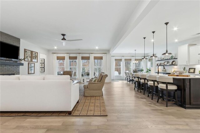 living room featuring ceiling fan and light wood-type flooring