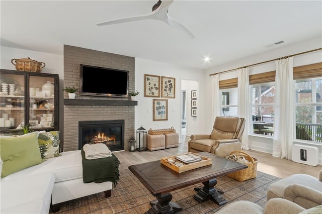 living room with ceiling fan, hardwood / wood-style floors, and a fireplace