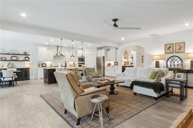 living room featuring ceiling fan and light hardwood / wood-style flooring