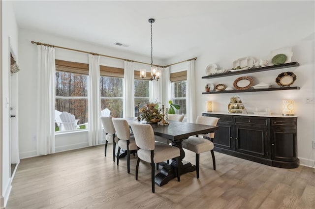 dining room featuring a notable chandelier and light wood-type flooring