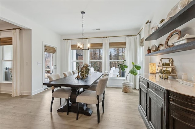 dining space with an inviting chandelier and light wood-type flooring