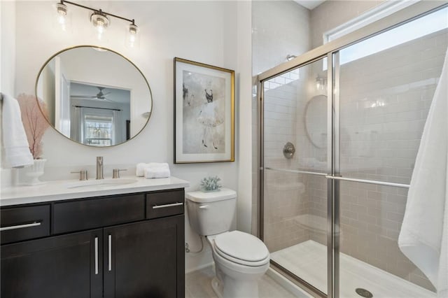 bathroom with vanity, ceiling fan, toilet, and walk in shower