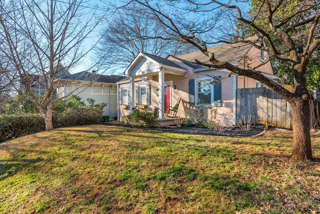 view of front of house featuring fence, a front lawn, and brick siding