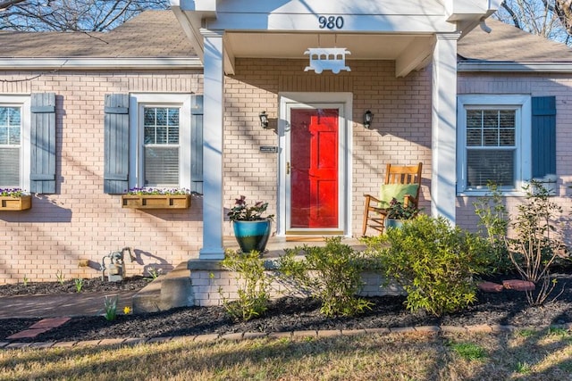 view of exterior entry with brick siding