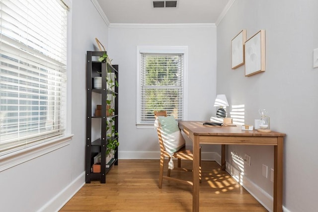 office with ornamental molding, wood finished floors, visible vents, and baseboards