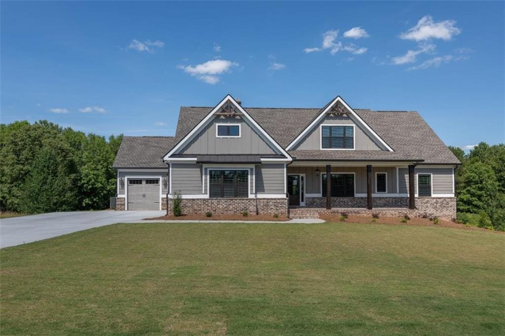 craftsman inspired home featuring a front lawn, a porch, and a garage