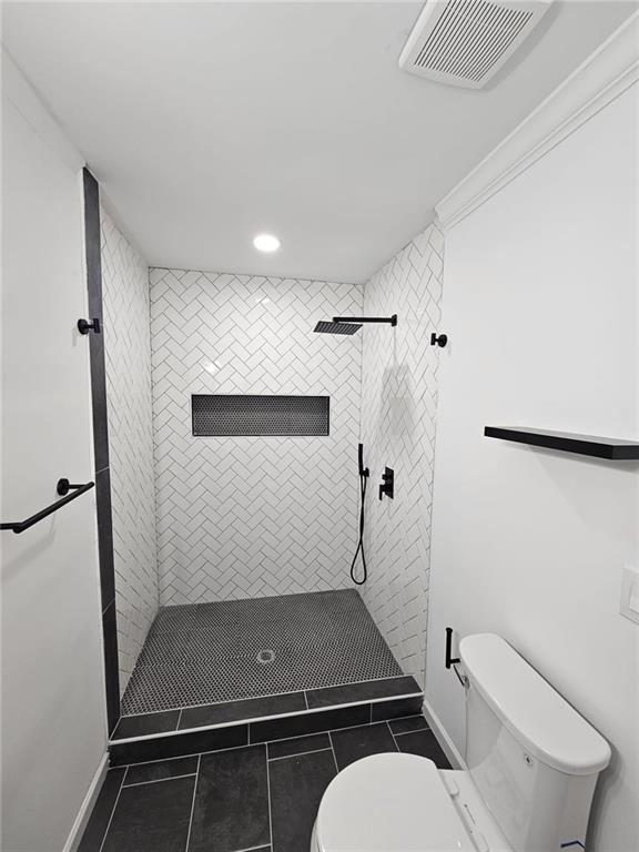 775 Lee Andrews Ave SE, Atlanta, GA 30315 - bathroom with toilet, tile patterned floors, tiled shower, recessed lighting, and baseboards